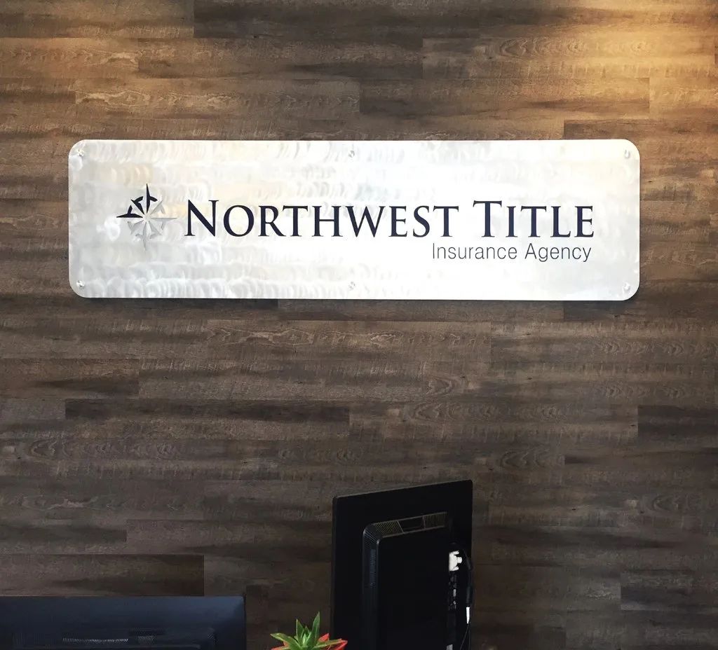 Northwest Title Insurance Agency sign on a wood-paneled office wall