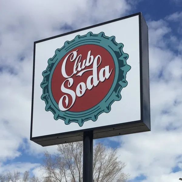 Cub Soda sign with red logo on a white roadside billboard against a cloudy sky