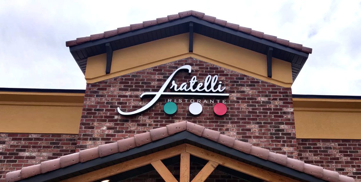 Fratellis restaurant sign on a brick building with teal, white, and red accent circles