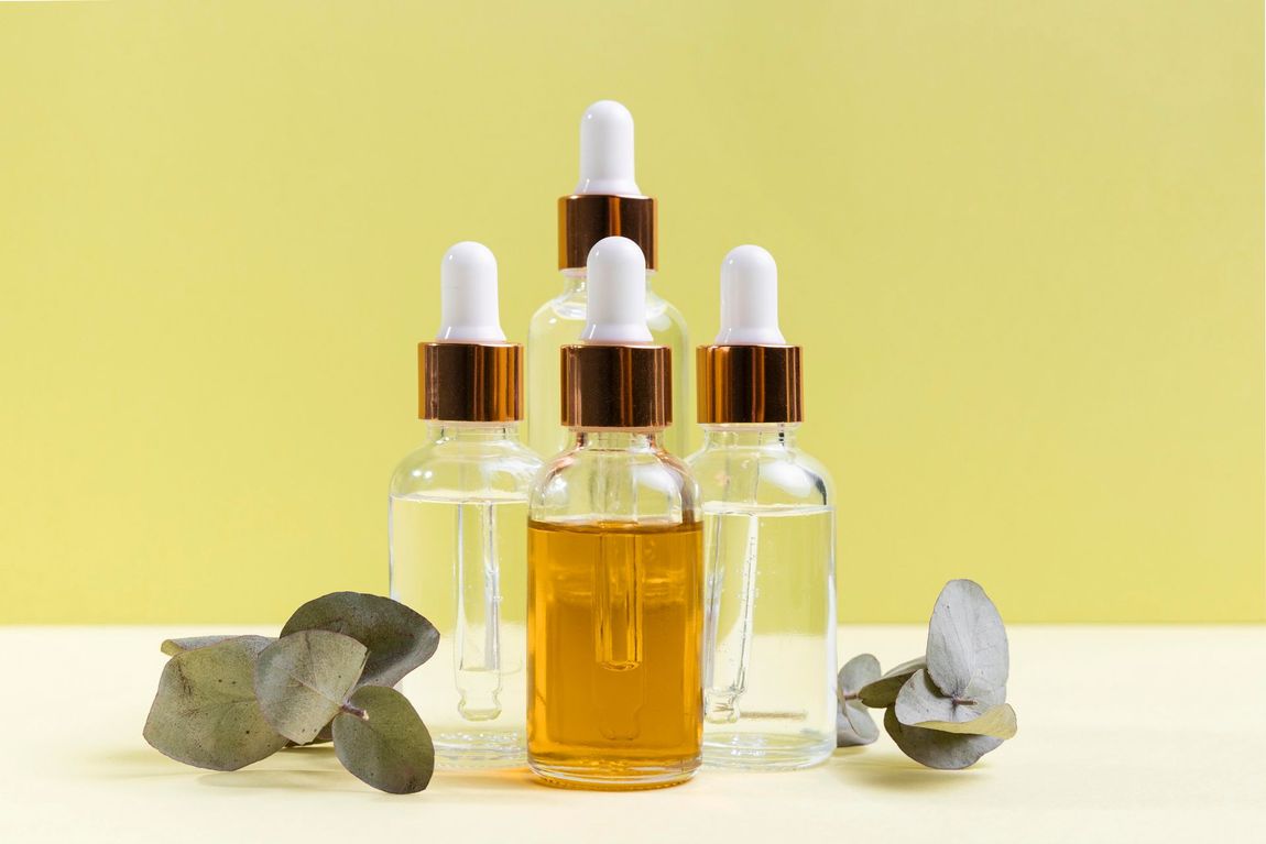 a group of bottles with pipettes and leaves on a table .