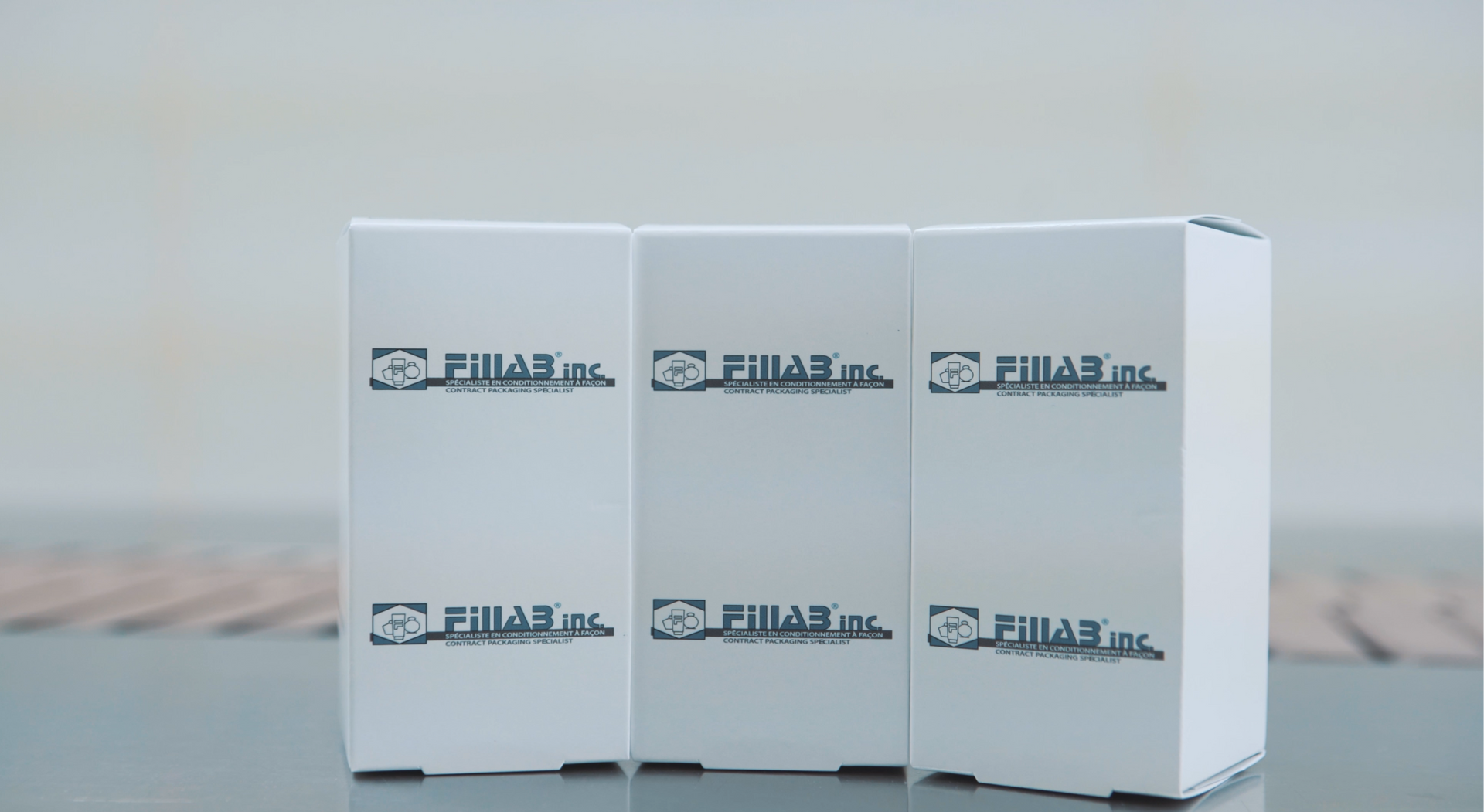 three white boxes with arabic writing on them are sitting on a table .