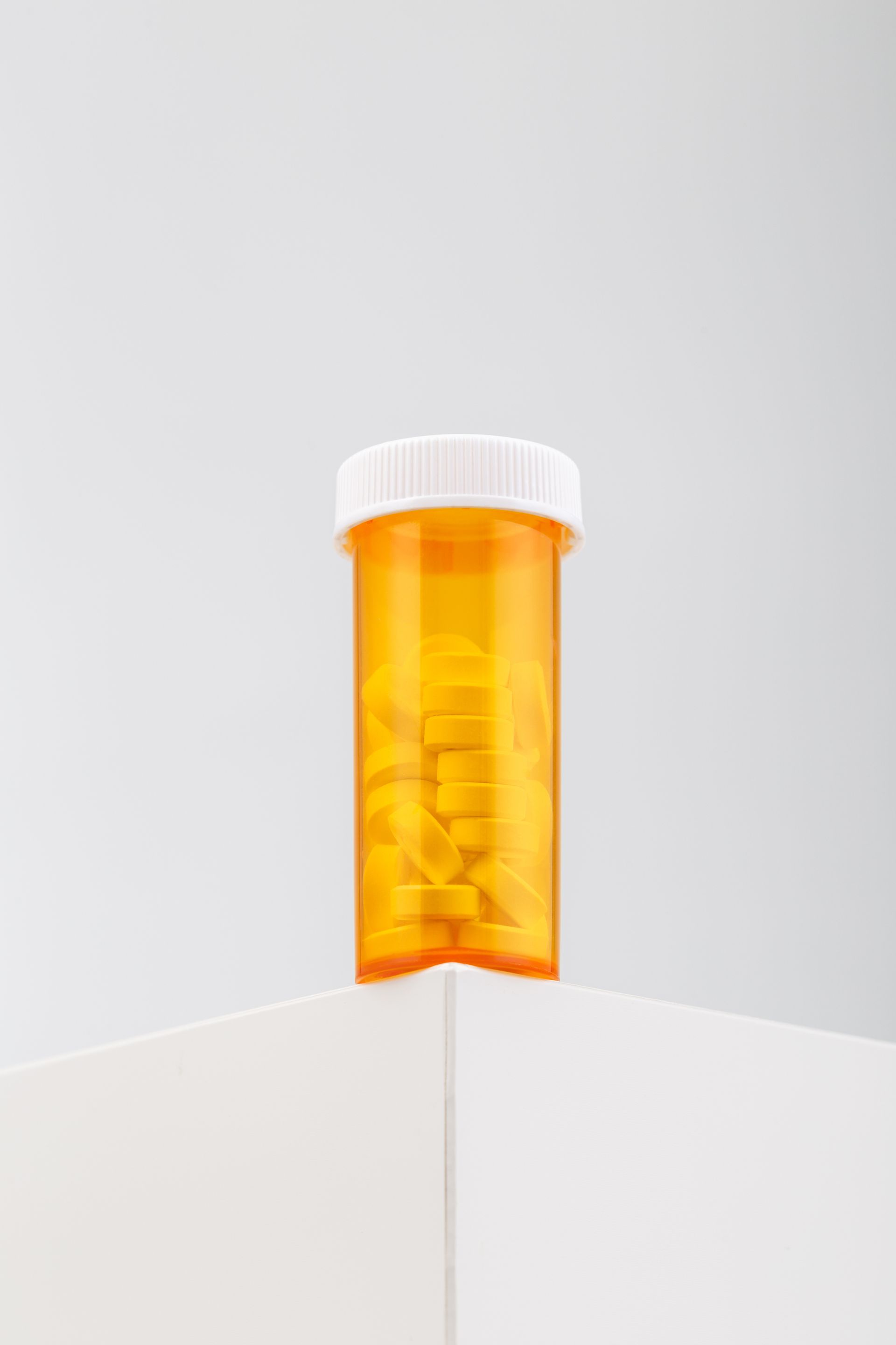 a bottle of pills is sitting on top of a white cabinet .