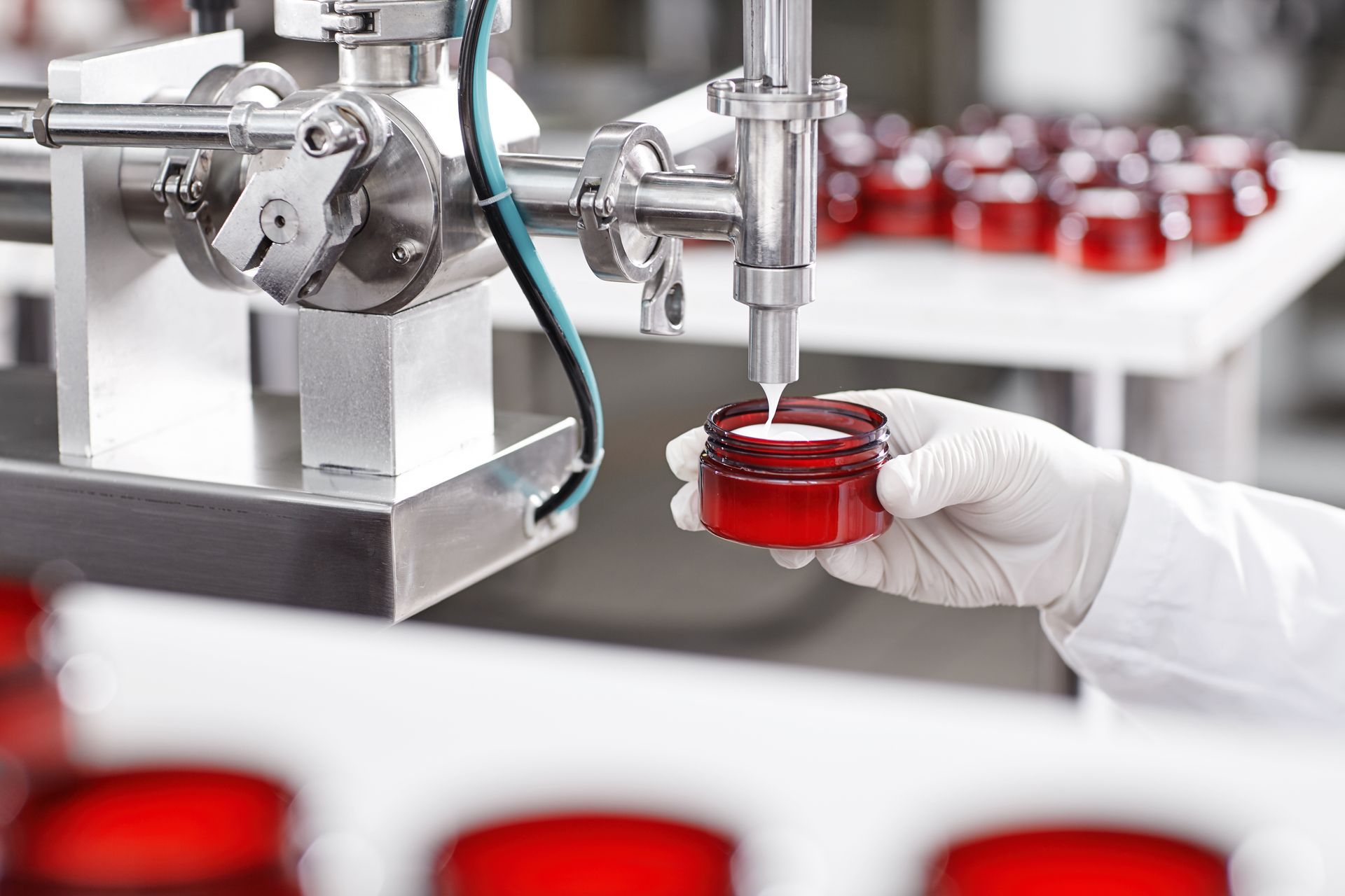 a person is holding a red jar in front of a machine .
