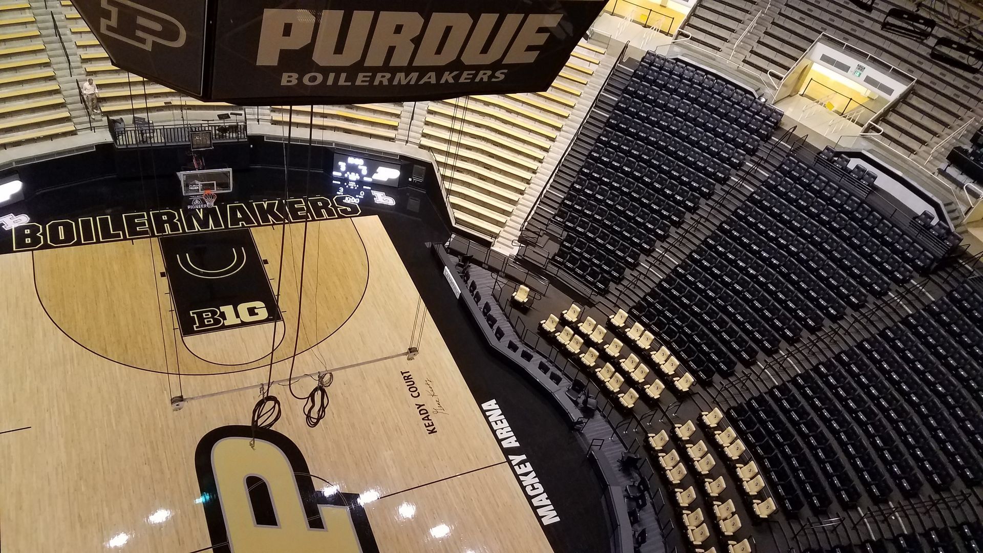 Overhead view of Purdue Boilermakers basketball court; black and gold colors, empty seats.