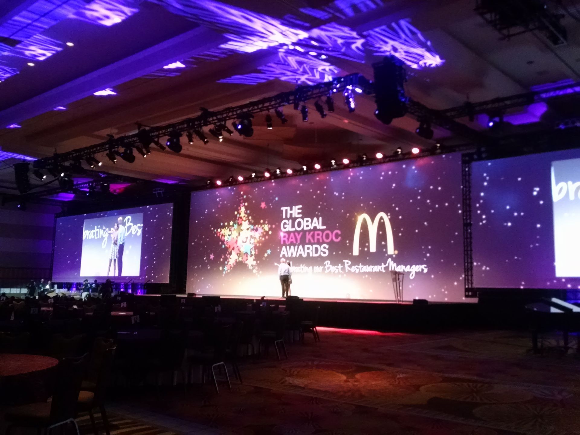 Stage set for McDonald's Ray Kroc Awards. Large screen with logo, spotlights, and purple lighting.