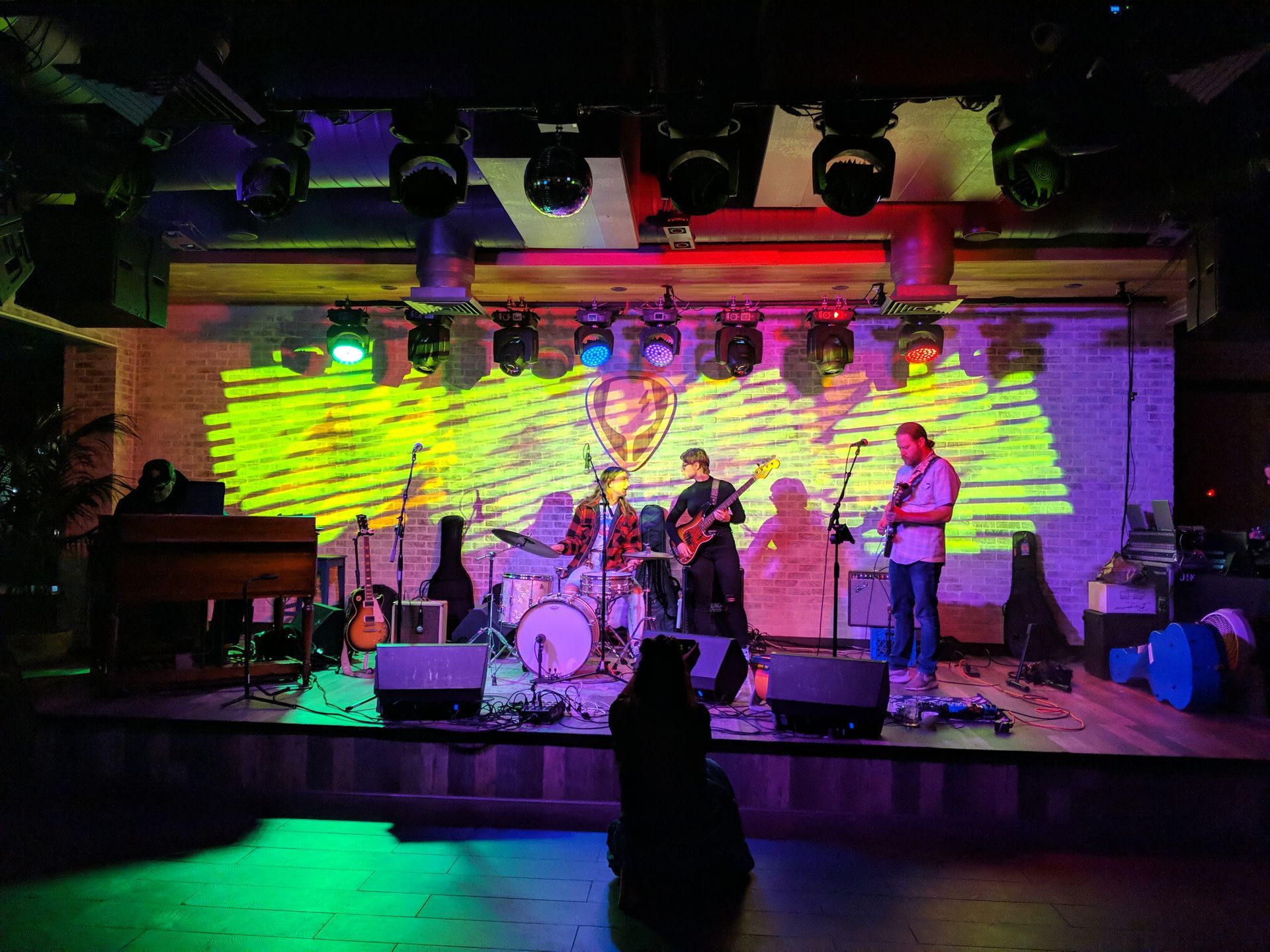 Band performing on stage under colorful stage lights.