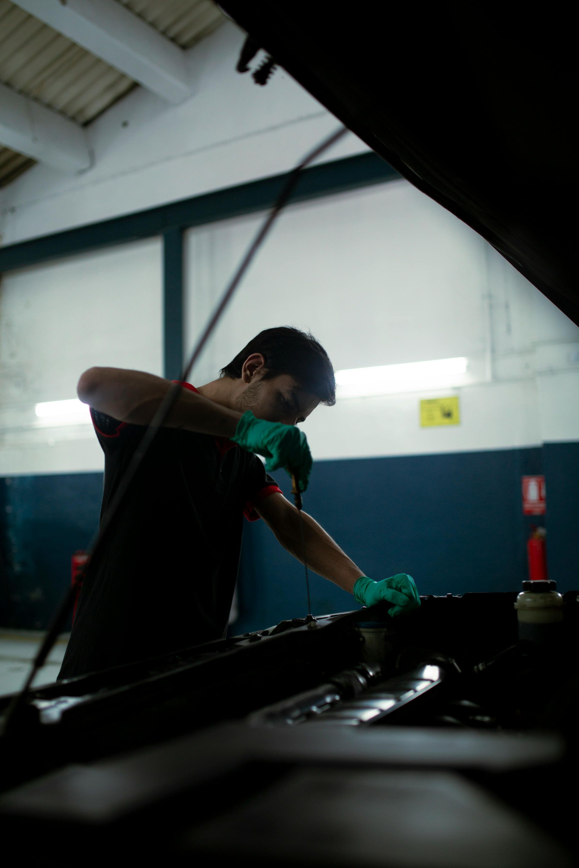 A man is working on a car with the hood open