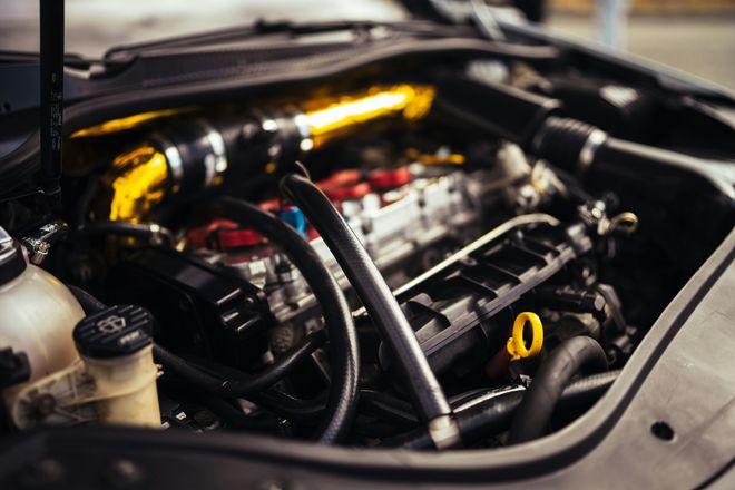 A close up of a car engine with the hood open.