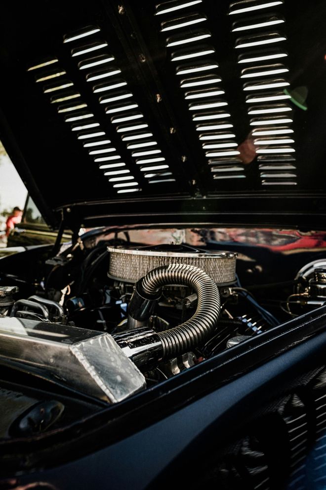 A close up of a car engine with the hood open.