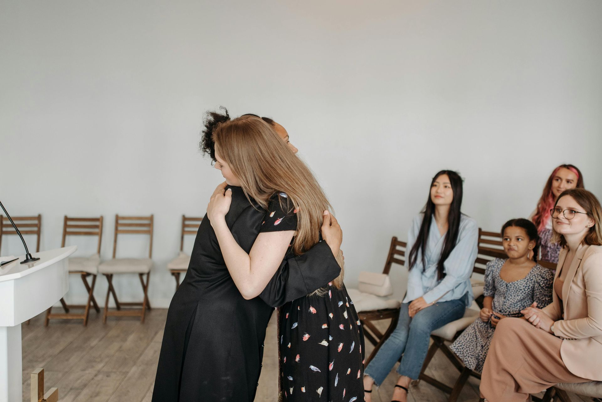 women hugging at a support group