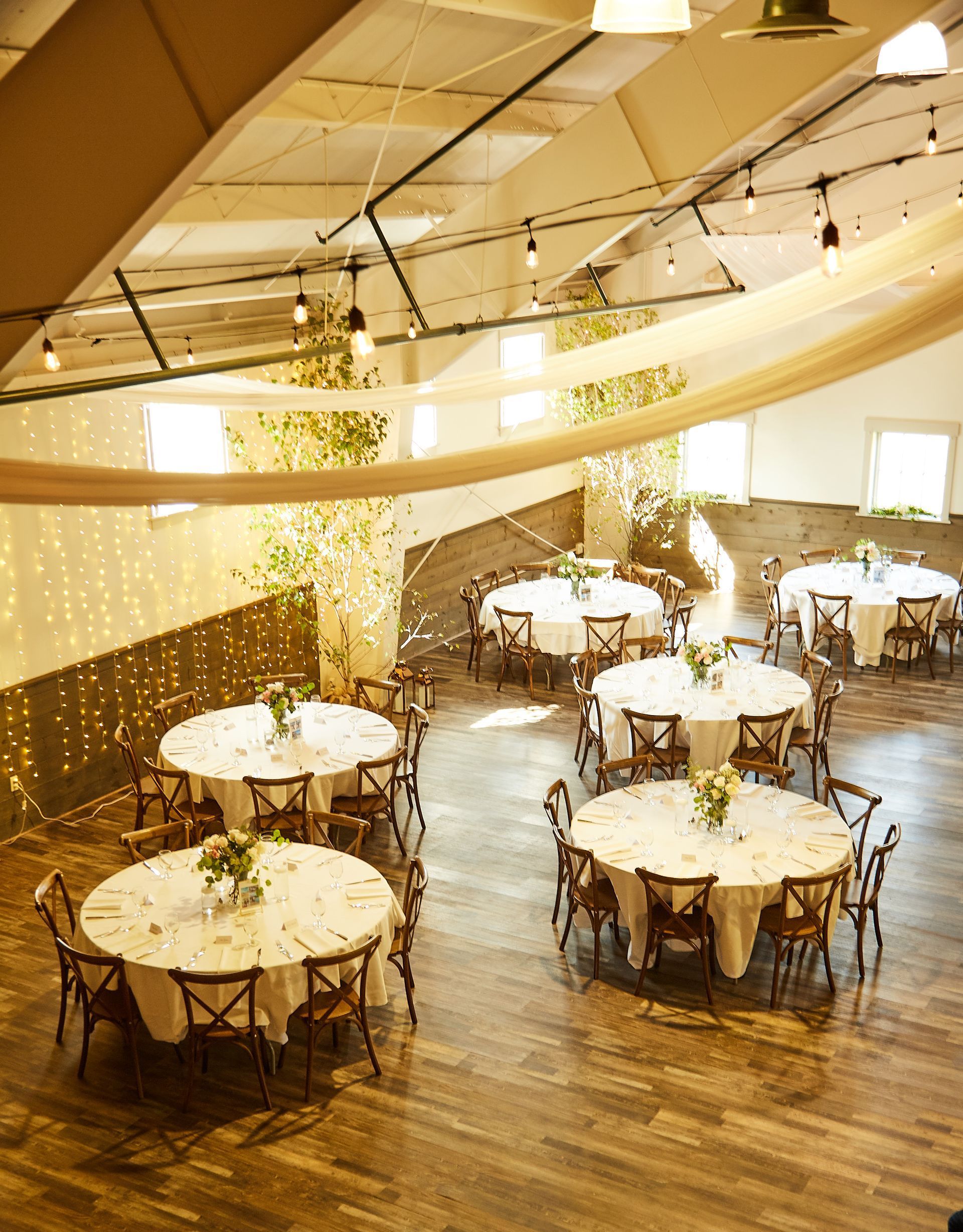 A large room with tables and chairs set up for a party