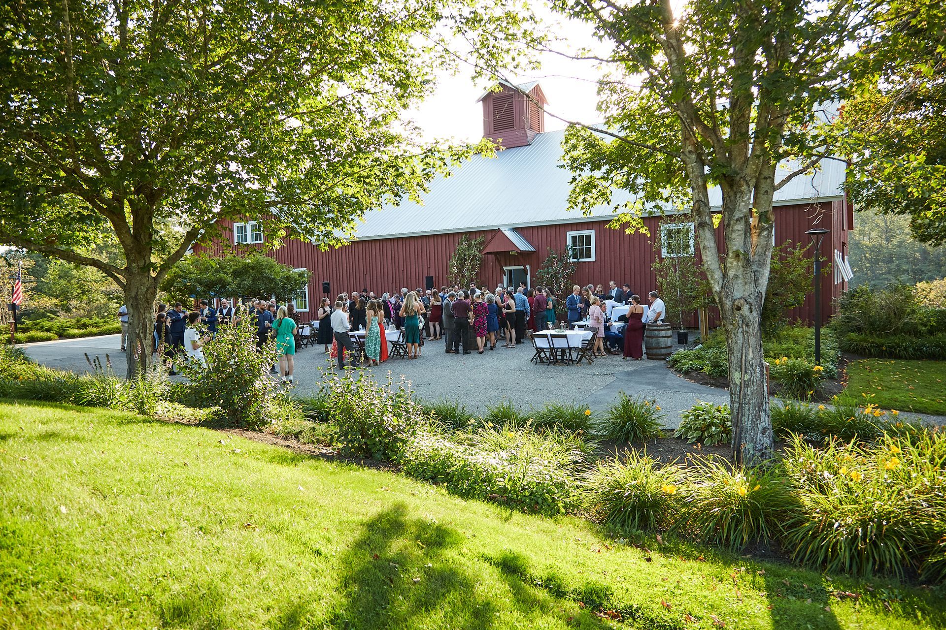 A group of people are standing in front of a red barn.