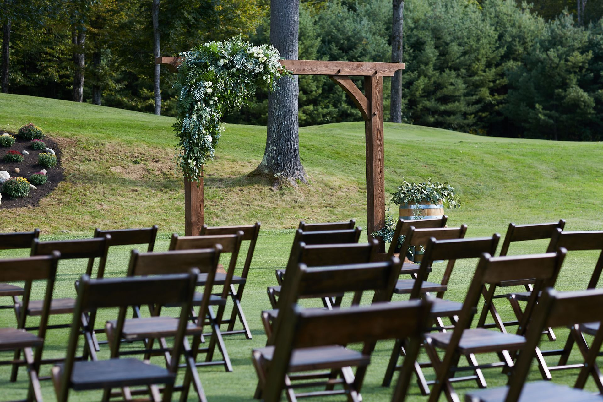 A row of wooden folding chairs on a lush green field