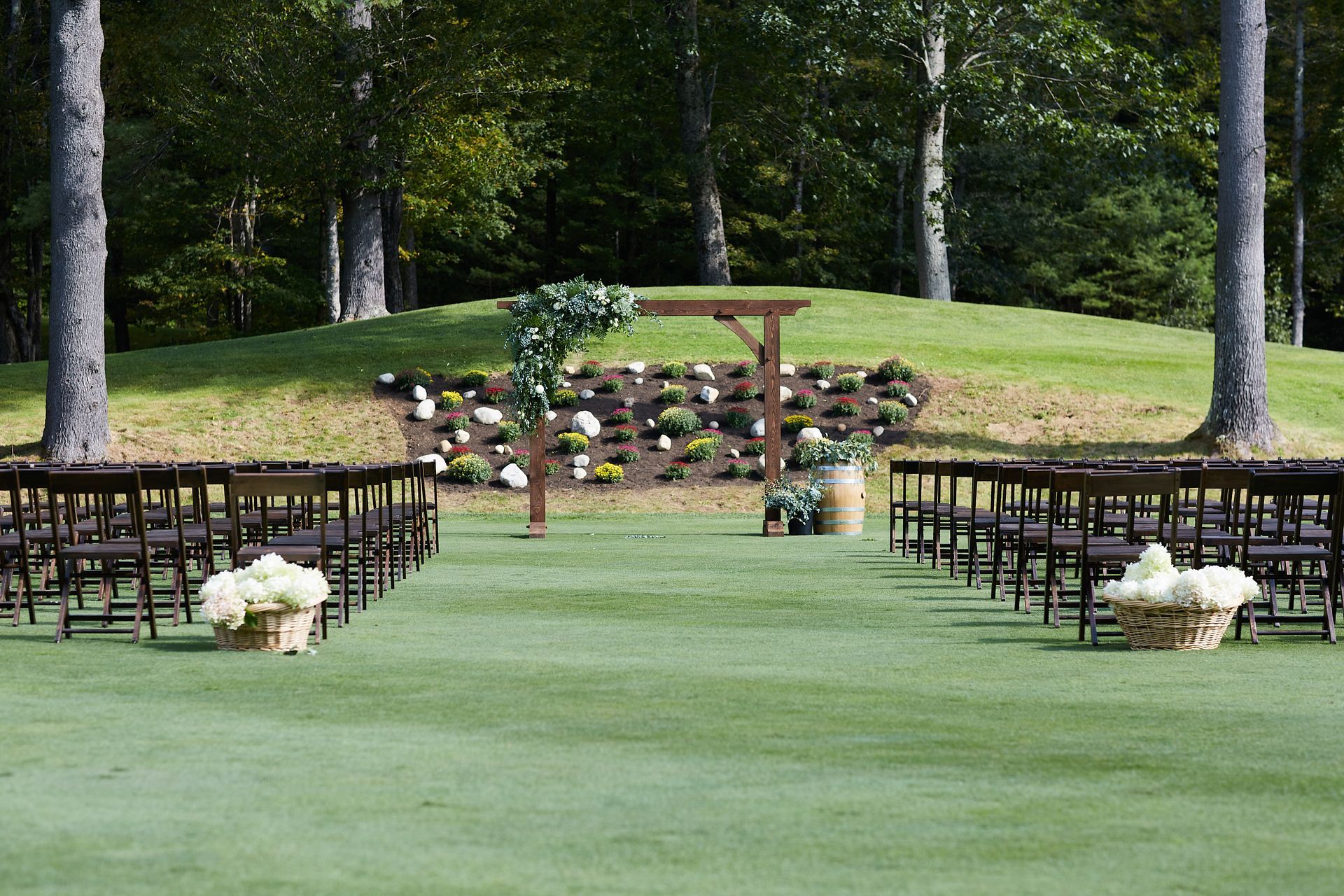 A row of chairs are lined up on a lush green field.