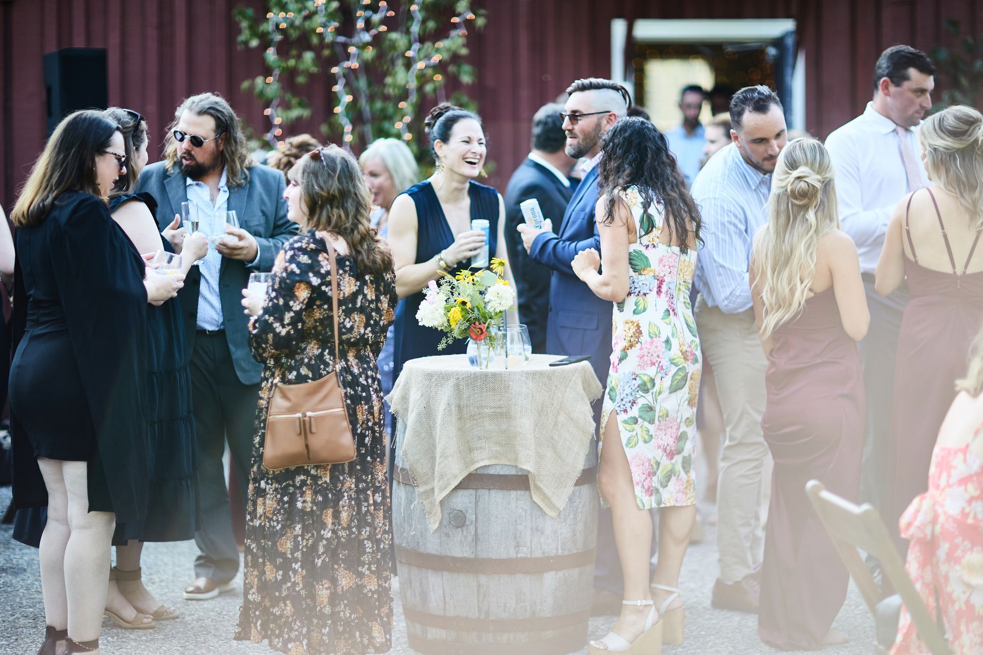 A group of people are standing around a table with a table cloth on it.