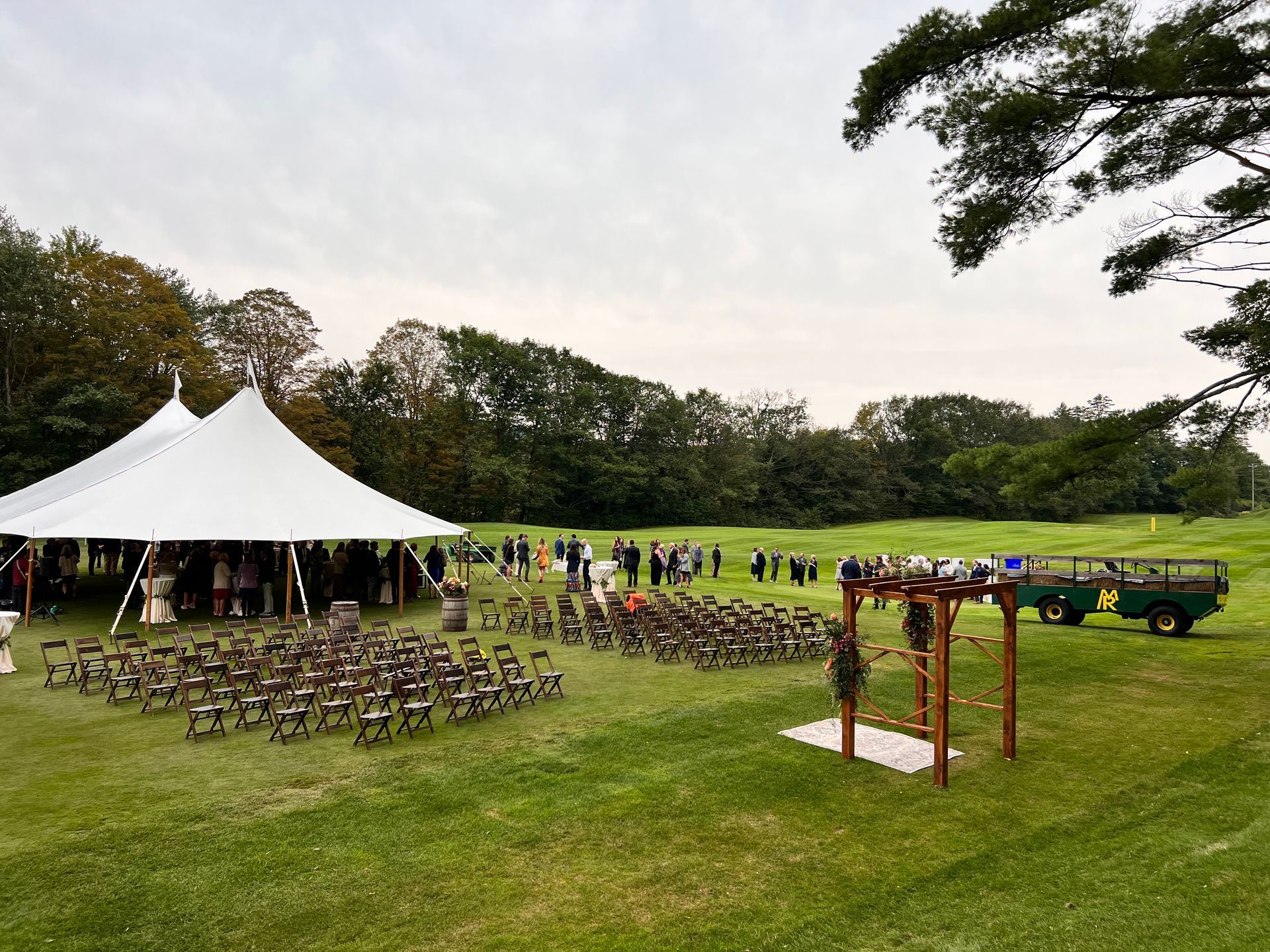 A large white tent is sitting in the middle of a grassy field.