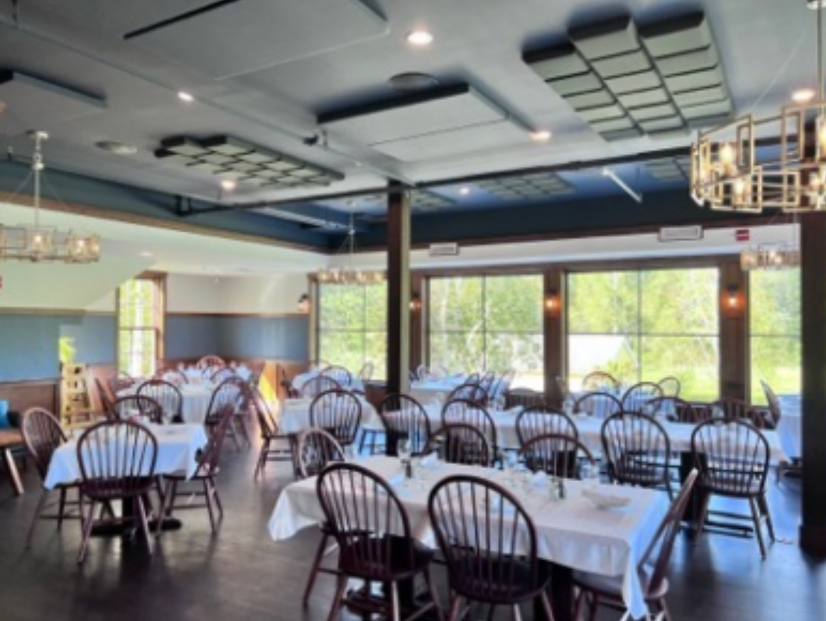 A large dining room with tables and chairs and lots of windows