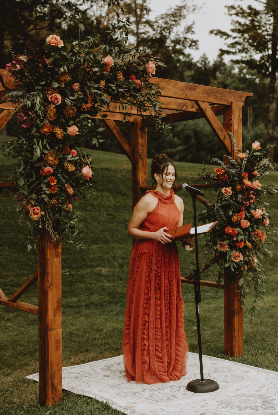 A woman in a red dress is standing in front of a microphone.