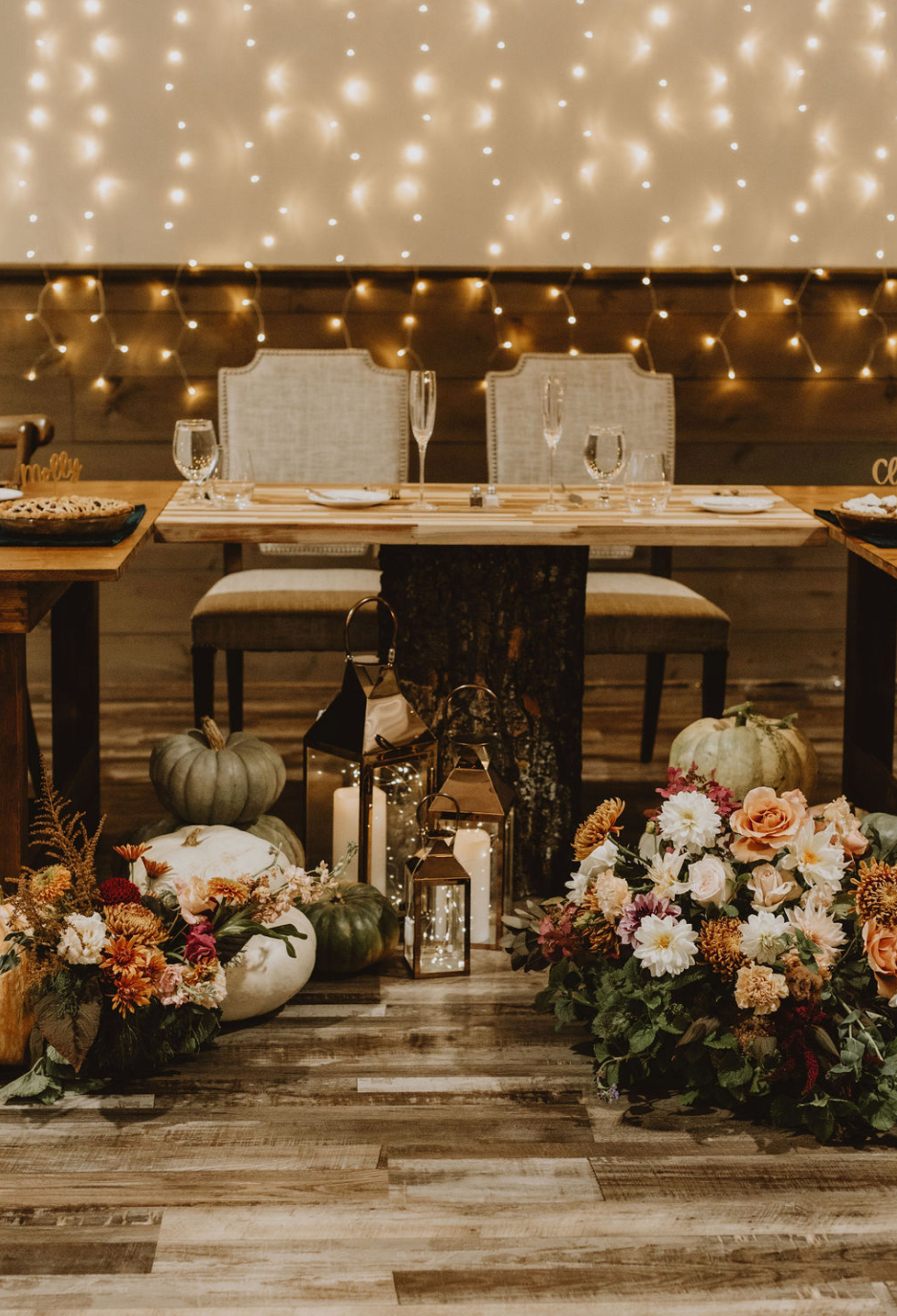 There is a table with flowers and pumpkins on it.