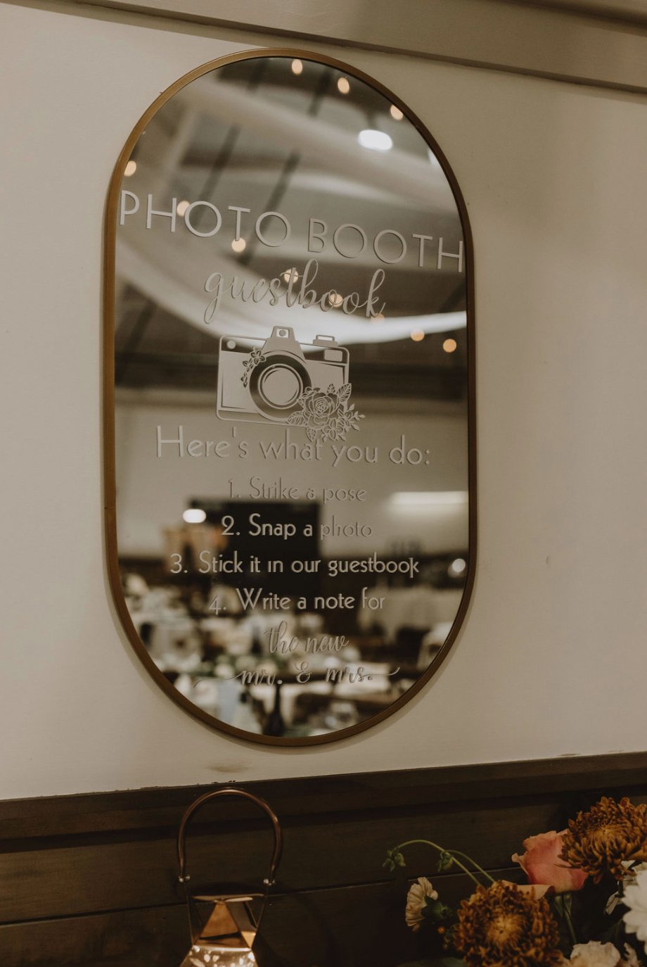 A large mirror with a camera on it is hanging on a wall.
