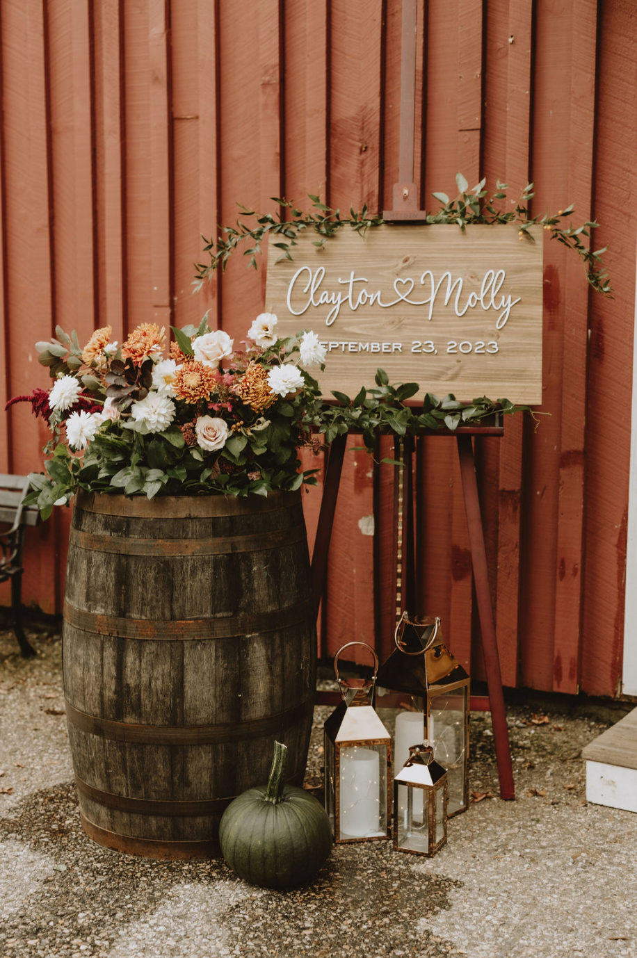 A wooden sign is sitting on top of a wooden barrel.