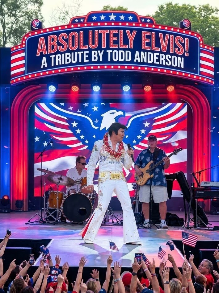 Elvis tribute performer in white jumpsuit on stage beneath “Absolutely Elvis!” marquee, crowd cheering at front