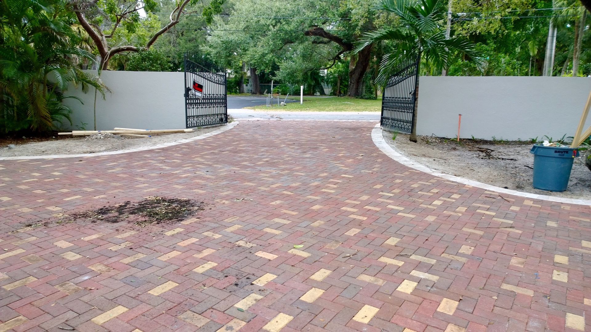 Curved pavement pattern of gray and black square tiles.