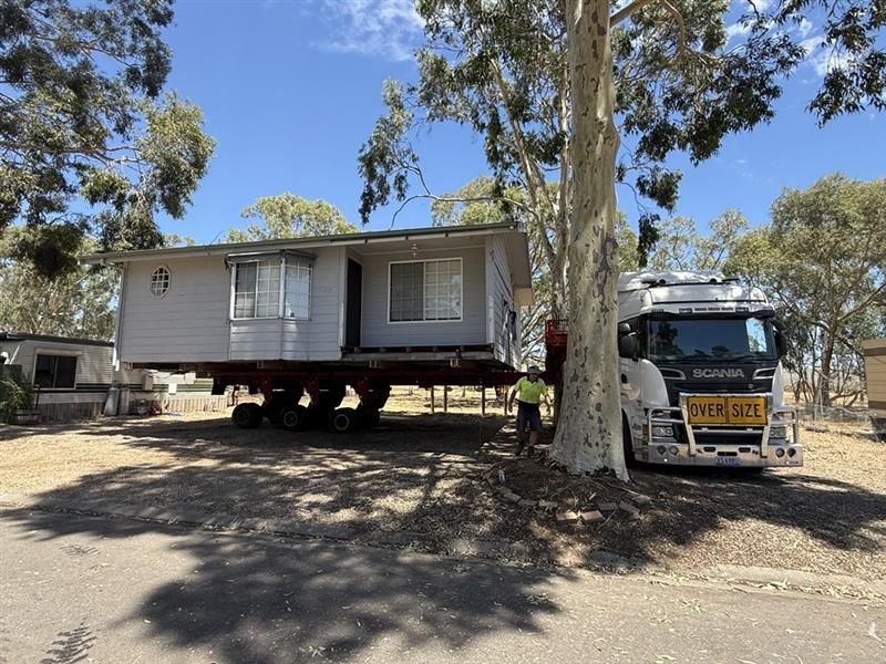 House being transported on truck with “OVERSIZE LOAD” sign on highway House being transported on truck with “OVERSIZE LOAD” sign on highway