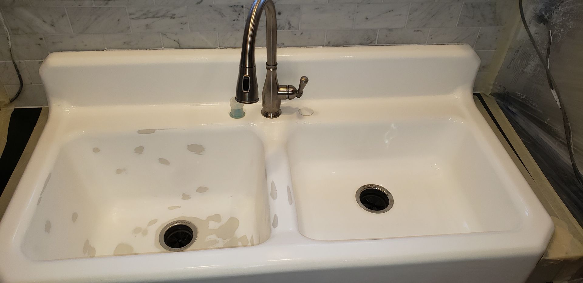 White double basin utility sink with chrome faucet.