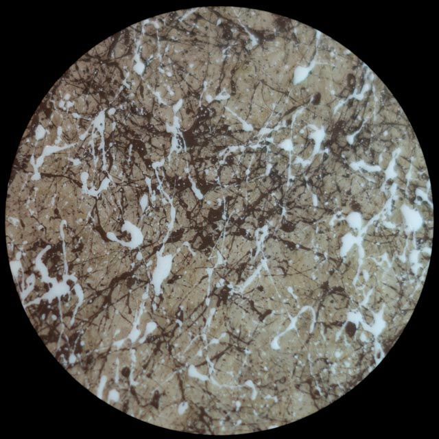 Circular brown and white marble pattern with black veins.