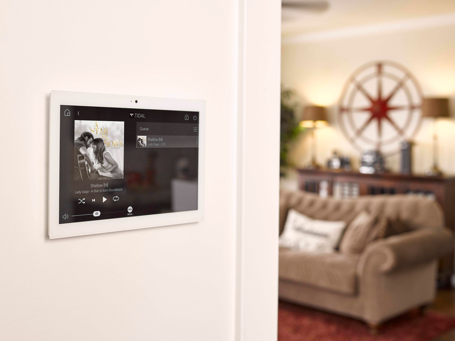 In-wall smart home control panel next to a living room seating area.