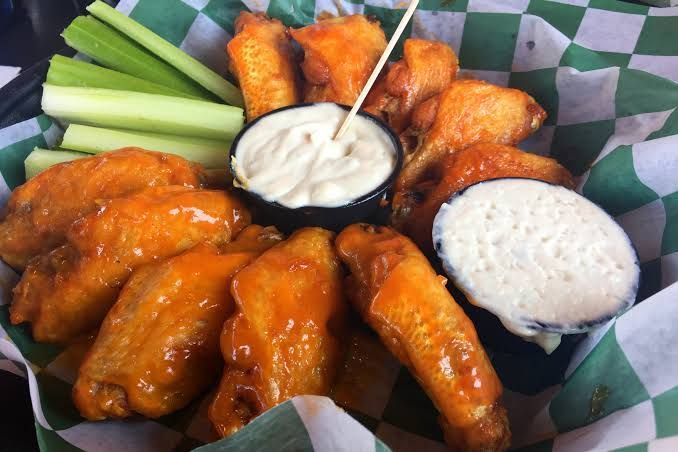 buffalo wings on a platter with celery and blue cheese