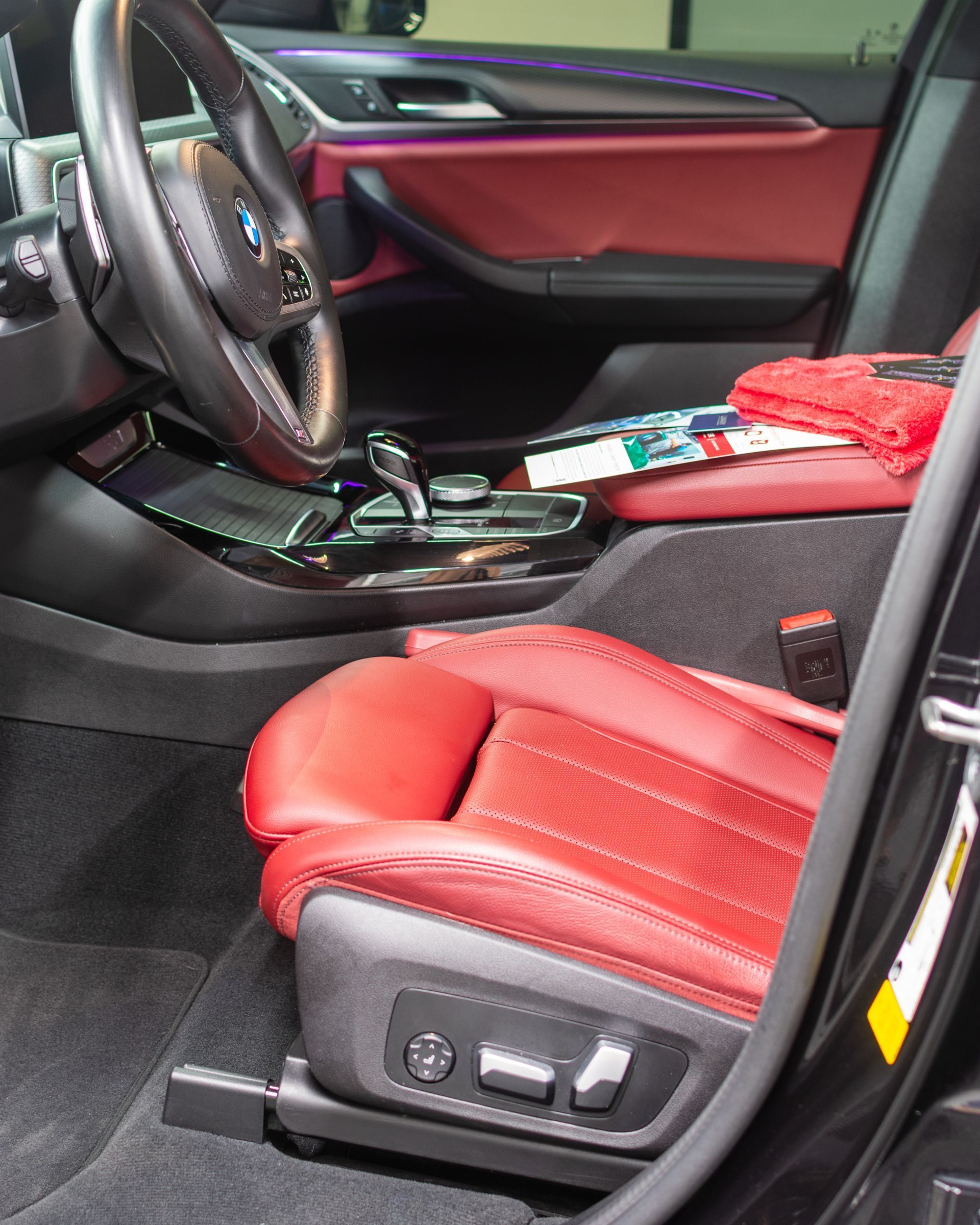 Red leather car interior with front seats and center console visible.