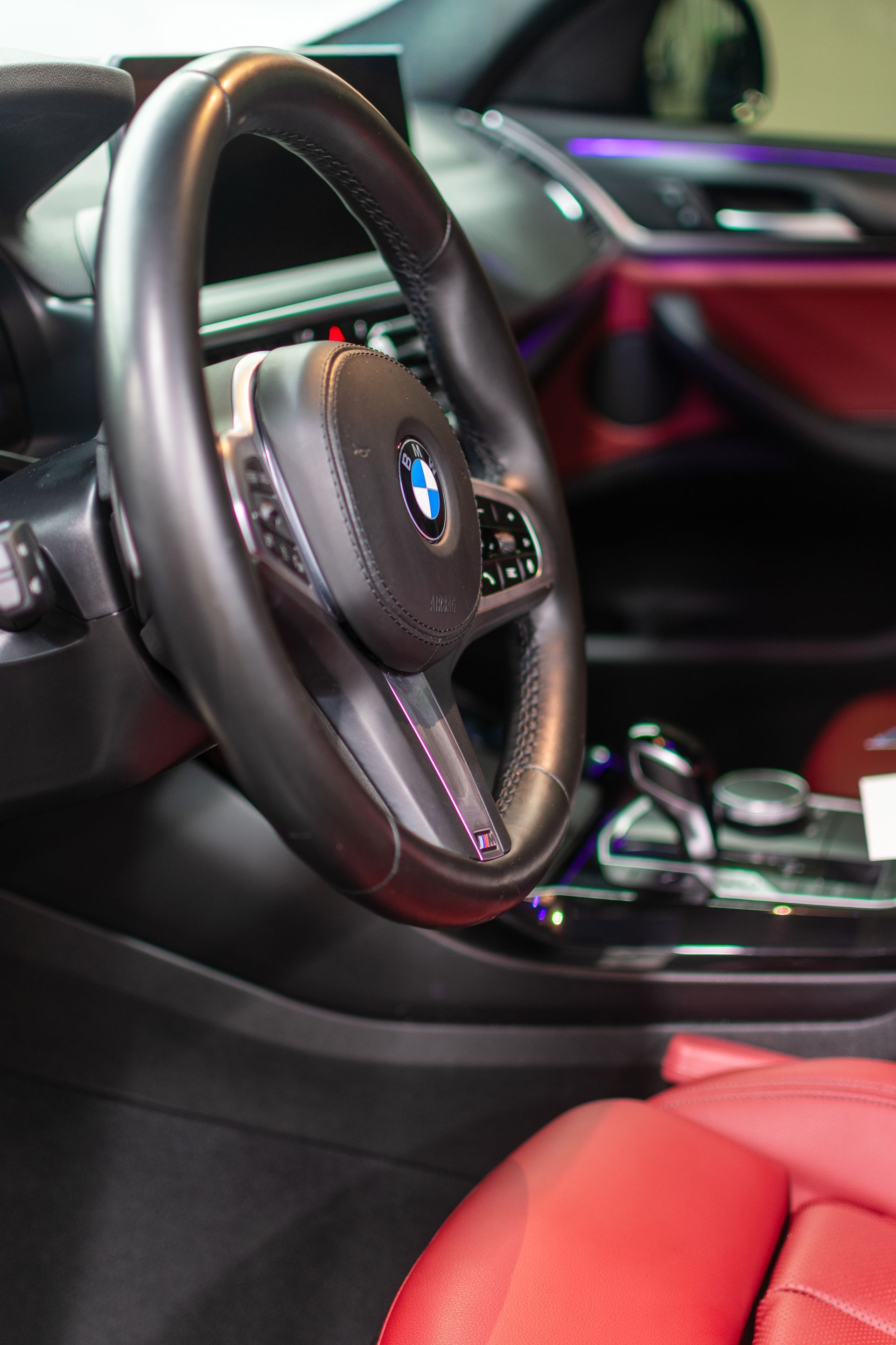 Gloved hand wiping a brown leather car seat with a white cloth
