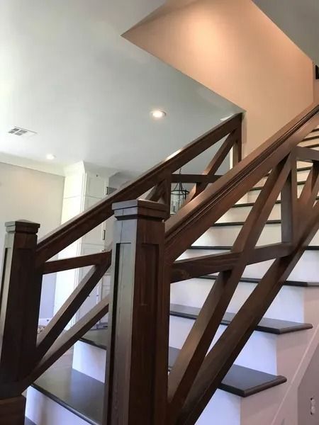 Wooden staircase with dark railings in a bright, modern interior lobby
