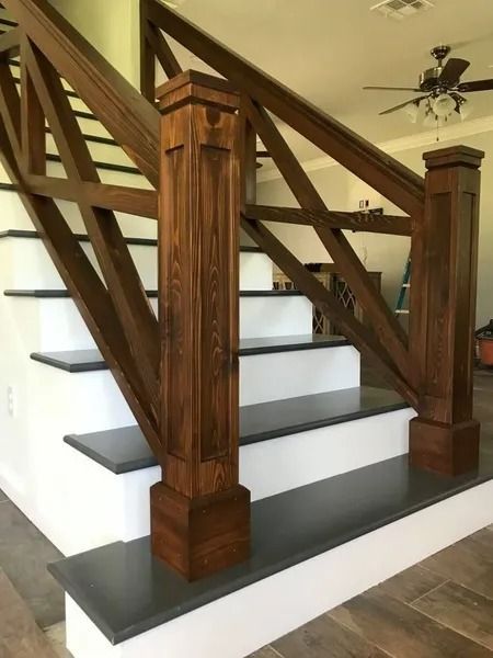 Wooden staircase with white risers and dark treads, featuring sturdy wood railings and posts.
