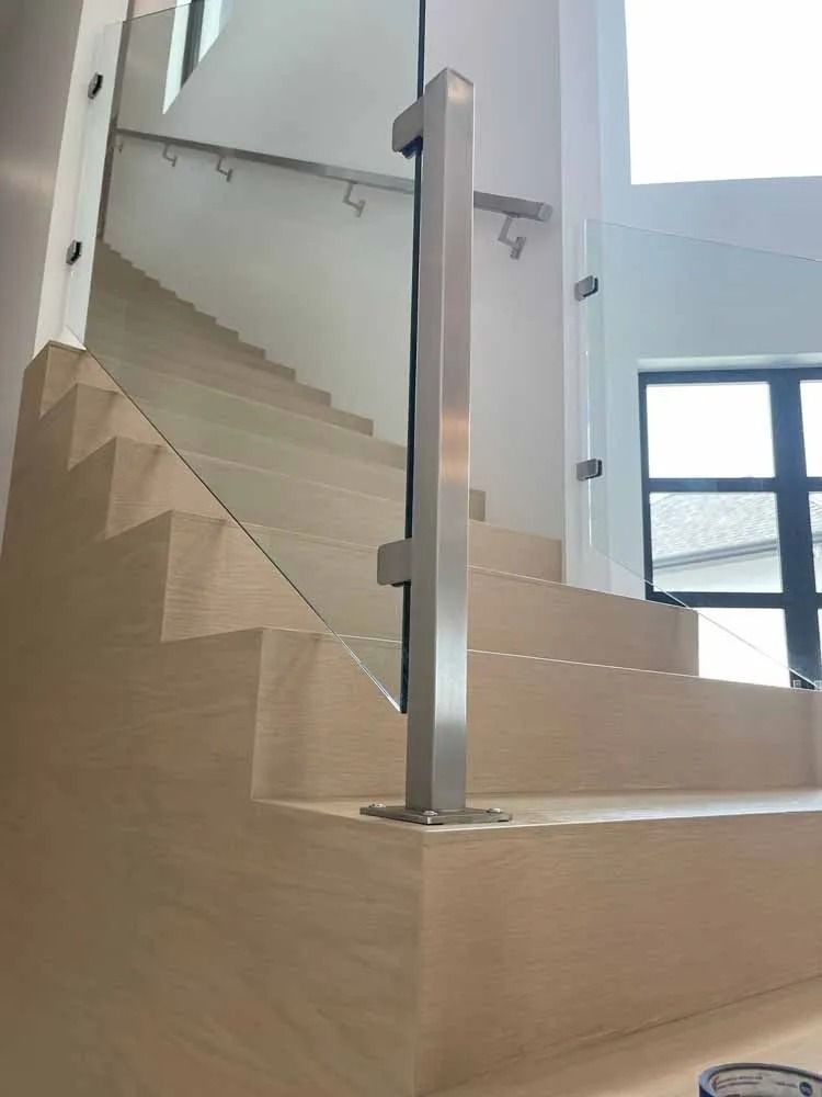 Staircase with light wood steps and a glass railing in a bright modern interior