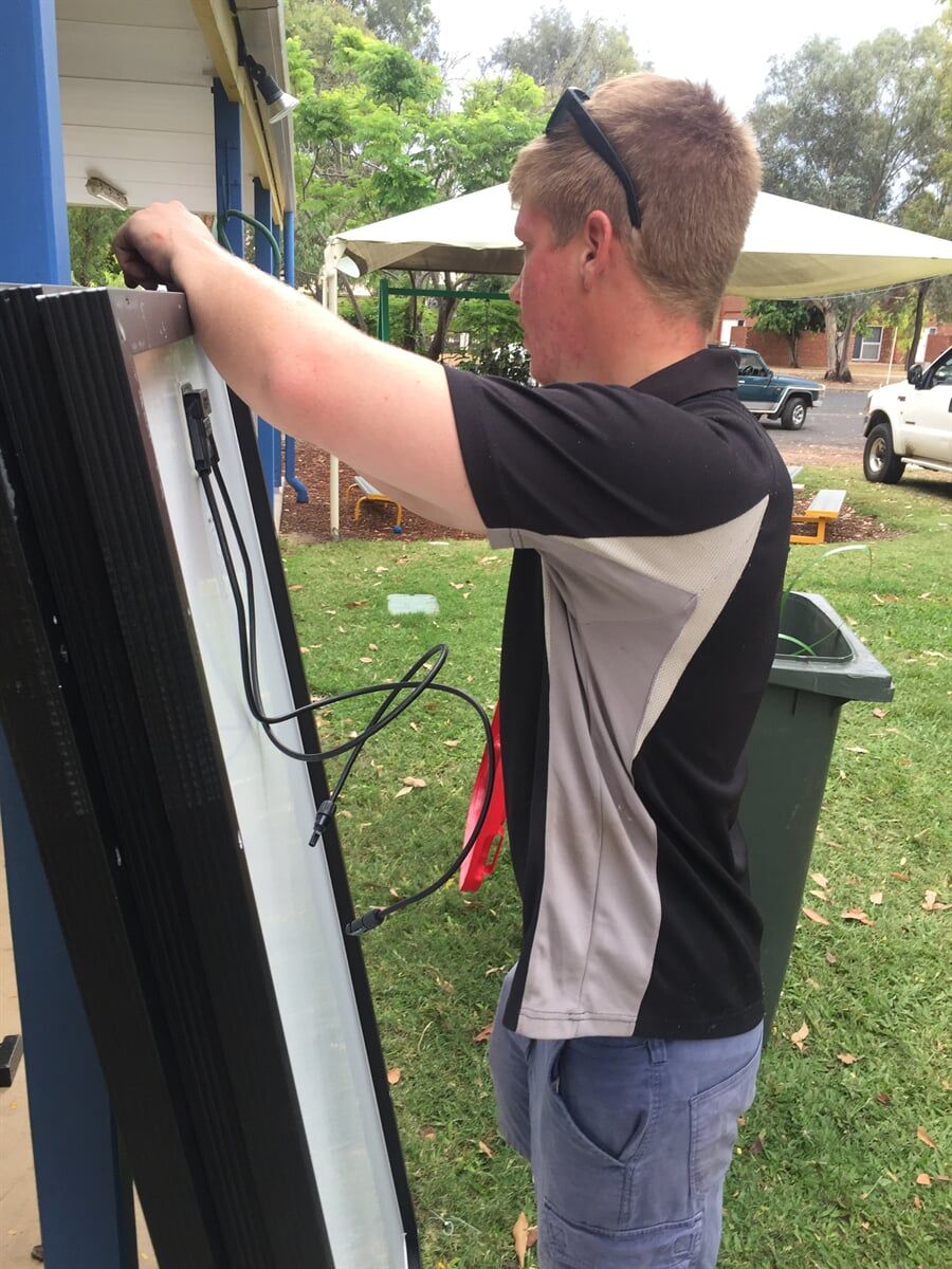 Man Holding Solar Panels — Solar Power Provider in Emerald, QLD