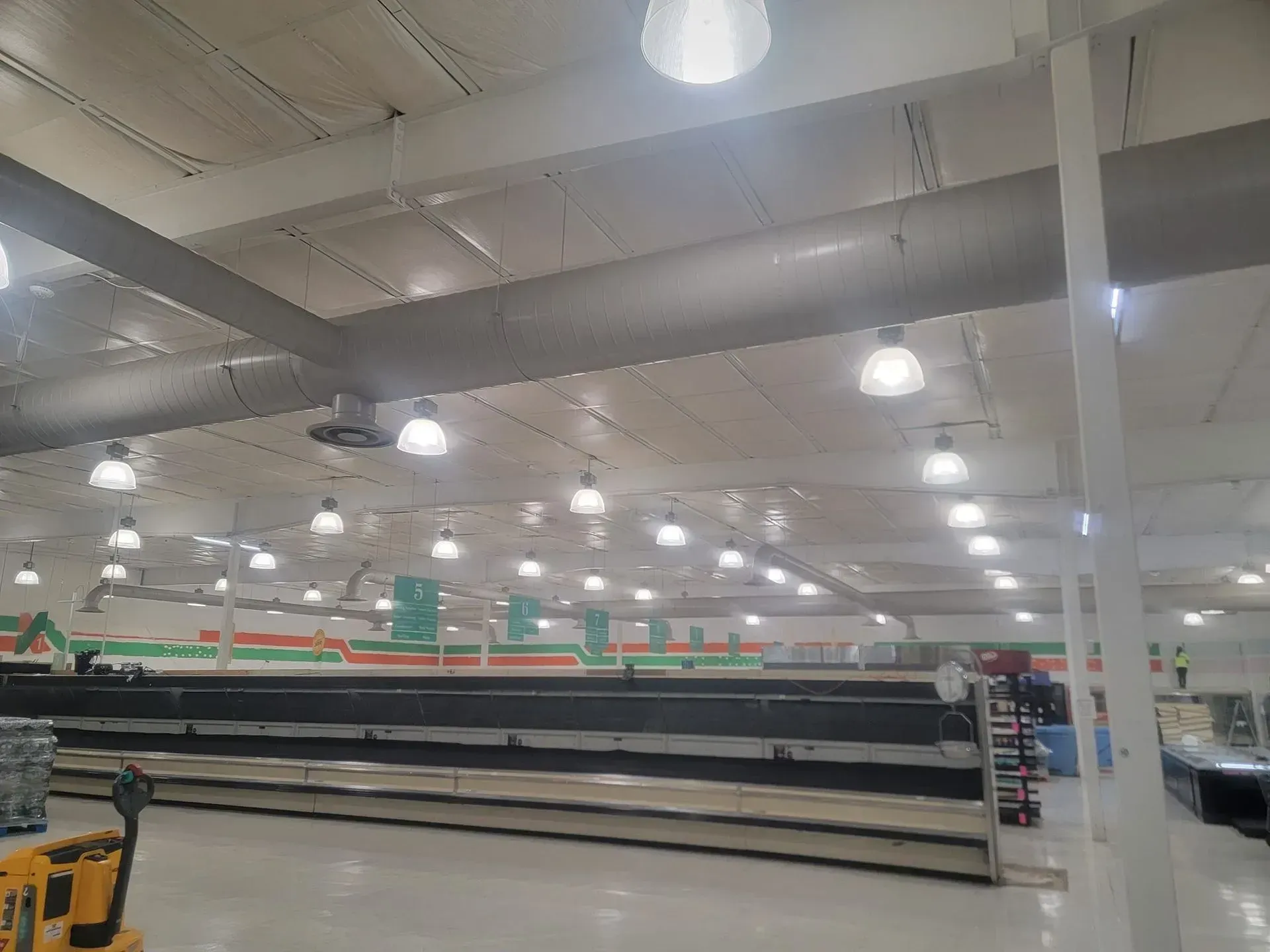 Empty store interior with bright lights and high ceilings. Shelves are mostly empty.
