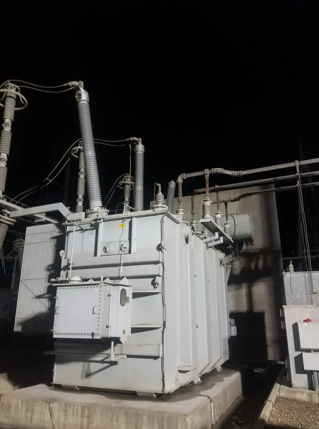 Large gray electrical transformer at night.