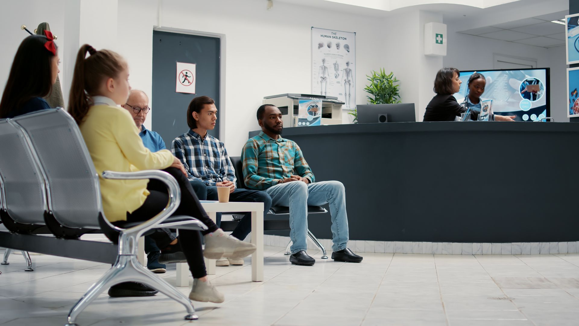 A group of people are sitting in a waiting room at a doctor 's office.