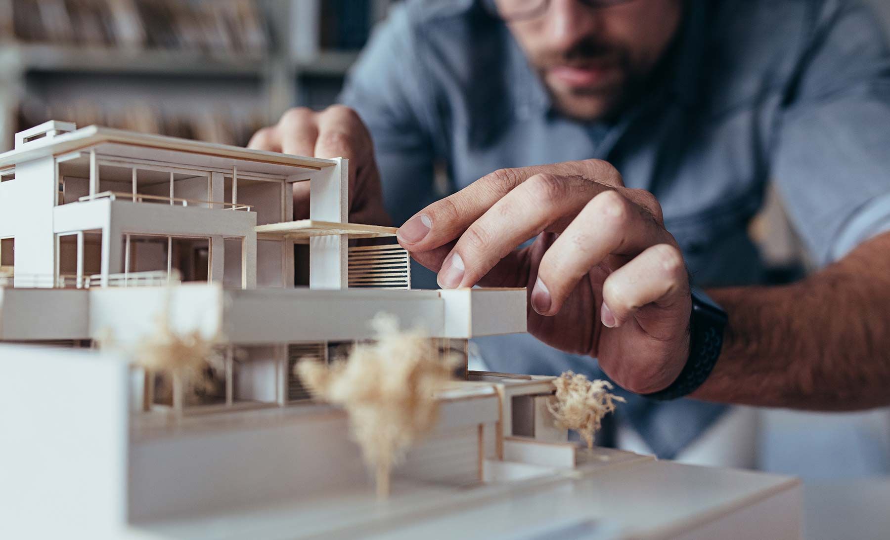 Architect adjusting a detailed architectural model of a modern house