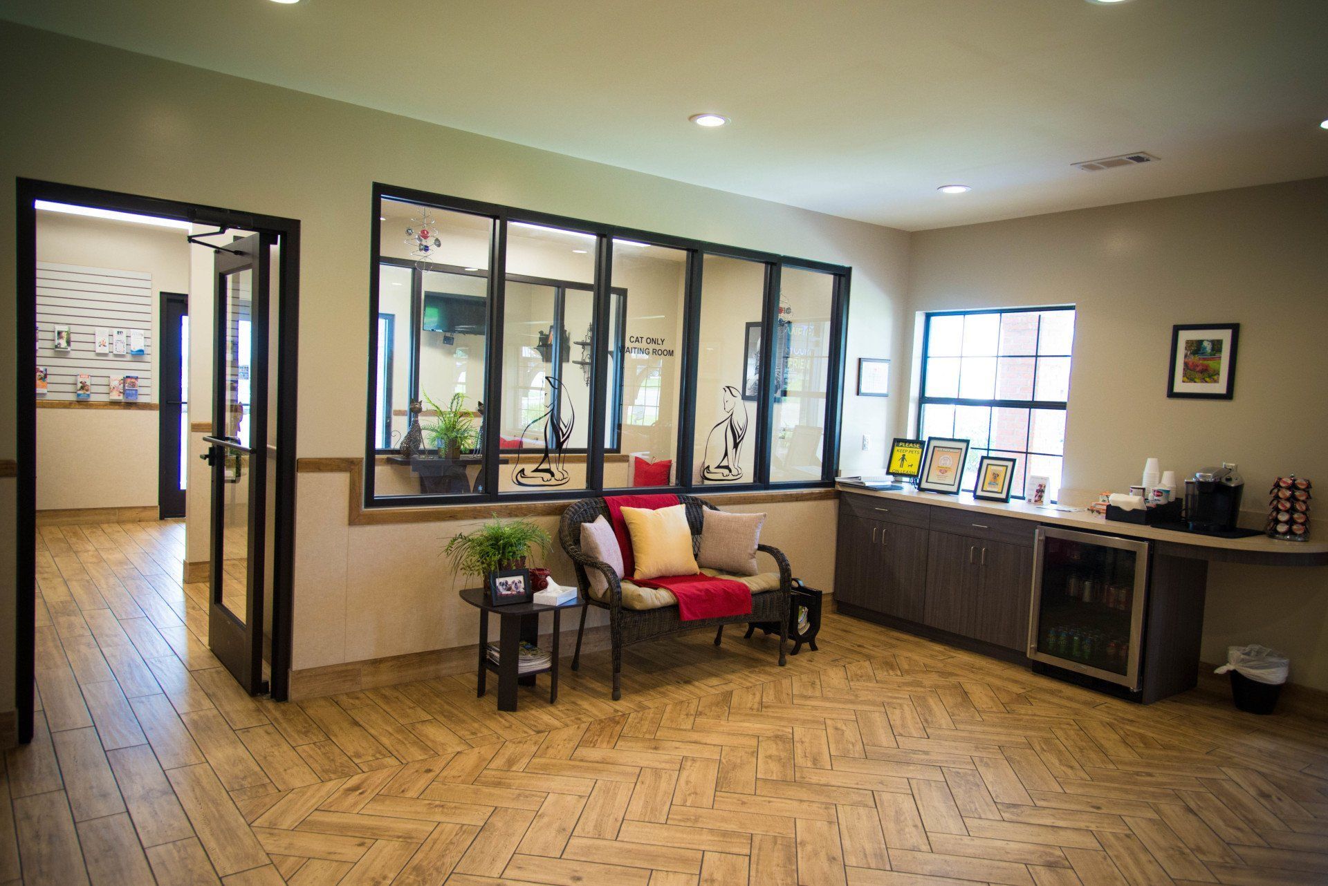 Lobby and waiting area with herringbone wood flooring and seating at Cobbs Ford Pet Health Center