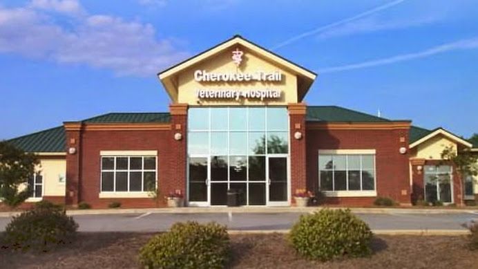 Exterior front entrance of Cherokee Trail Veterinary Hospital with brick facade, green metal roof, and signage in Lexington SC
