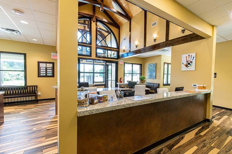 Warm-toned lobby and reception area with vaulted ceiling at Grace Animal Hospital