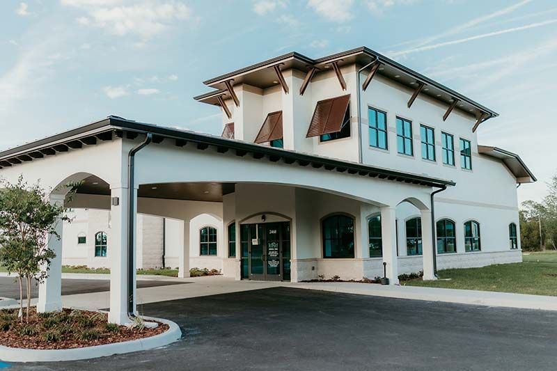 Exterior front entrance of Kind Animal Care veterinary clinic with covered drop-off area