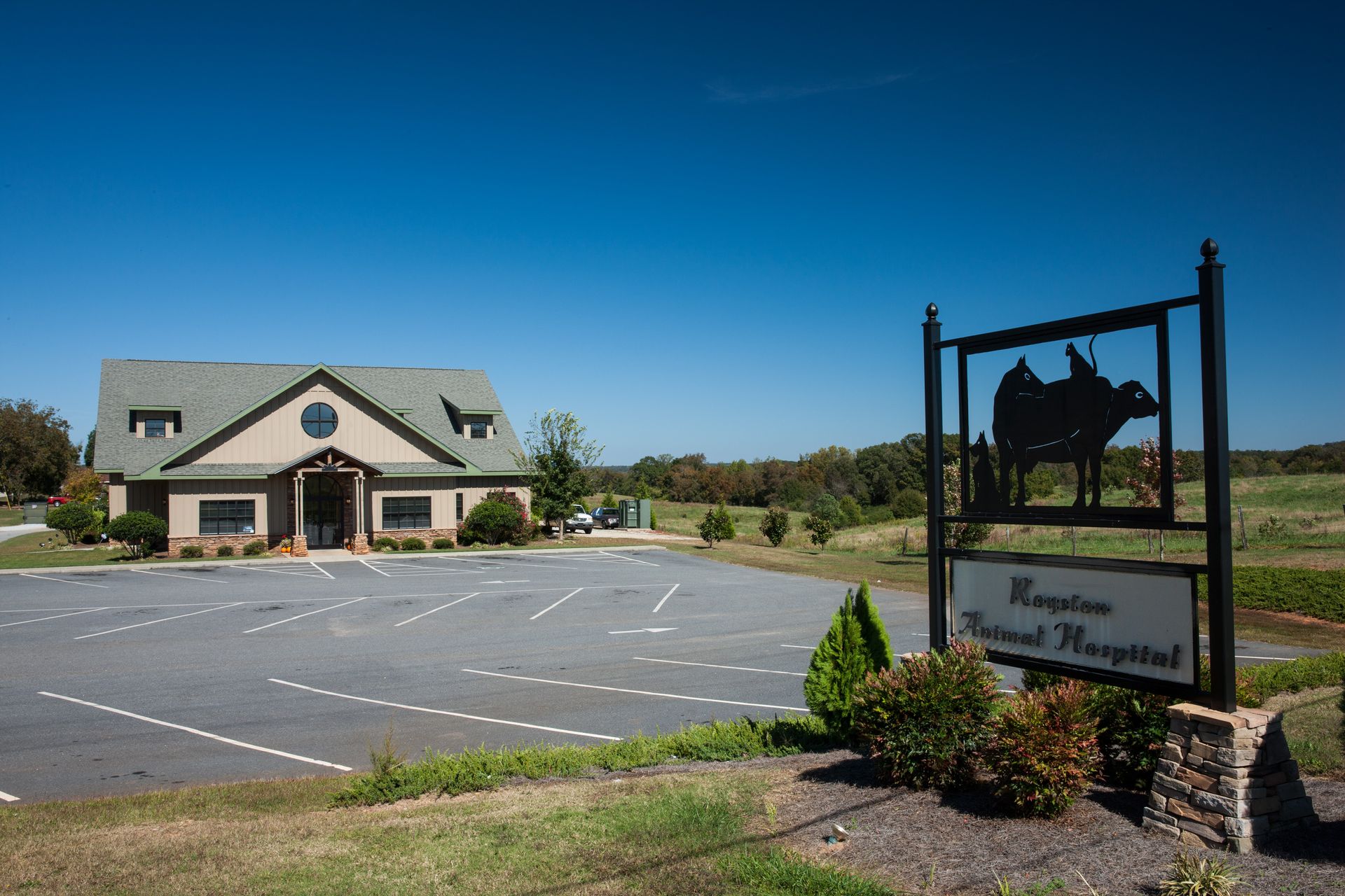Exterior view of Royston Animal Hospital with entrance signage, parking area, and open sky