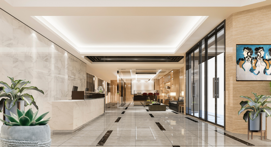 Modern lobby interior with marble floors, glass doors, potted plants, and wall art