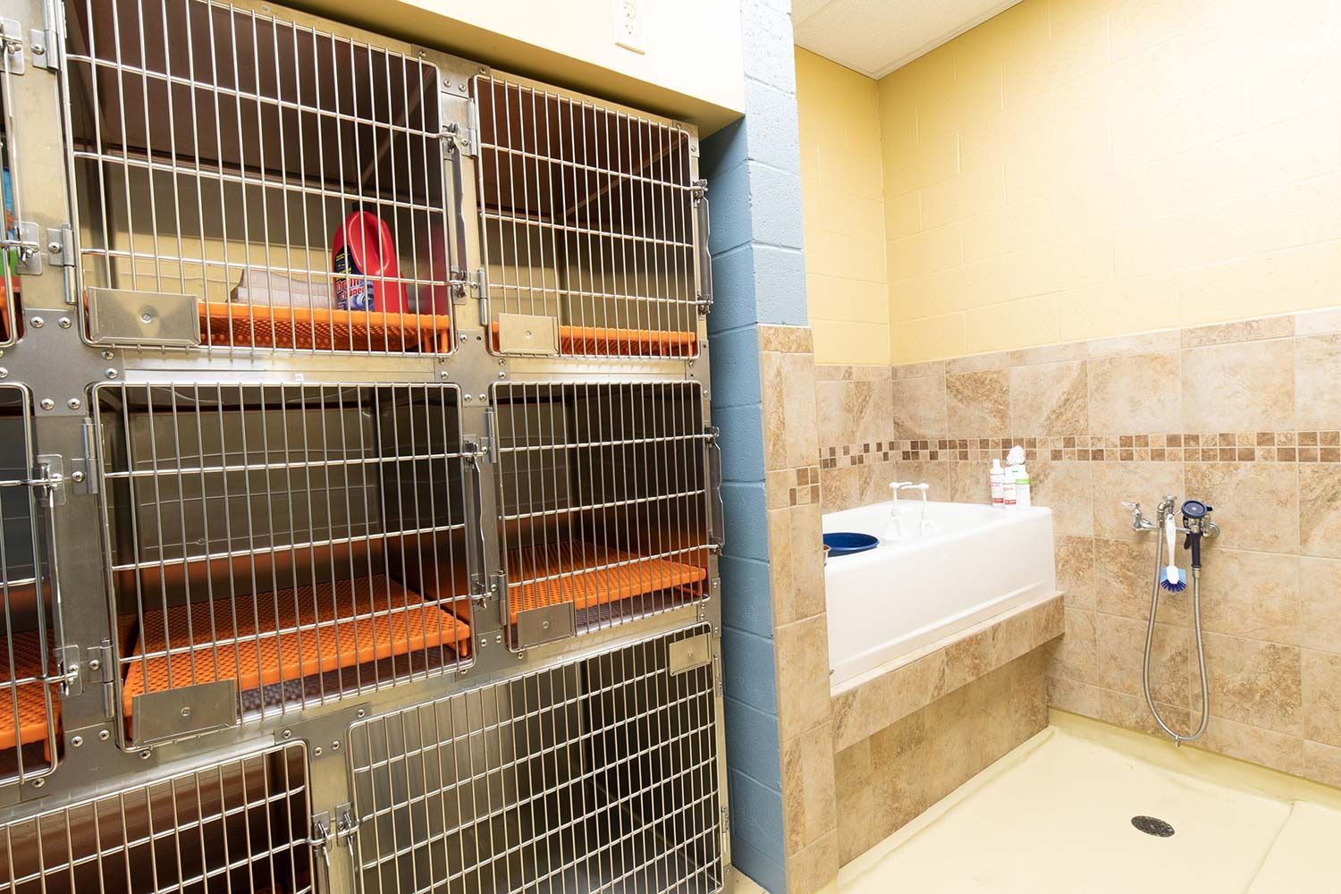Small storage area with metal cages beside a tiled bathroom sink and shower.