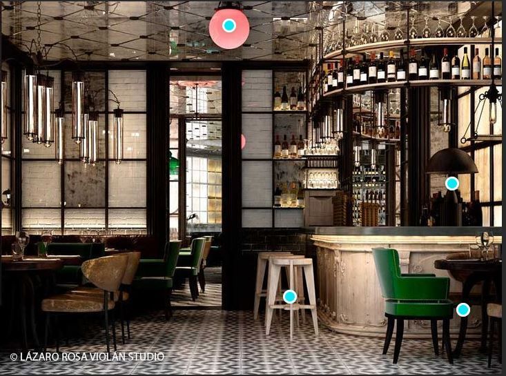 Stylish bar interior with green chairs, marble tables, and shelves of bottles under warm lighting